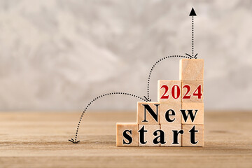 Cubes with text 2024 NEW START on wooden table