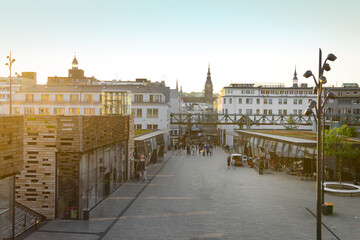 Fototapeta premium View of city street with buildings and walking people