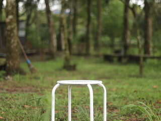 White garden chairs in the middle of the forest with grass