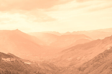 Fototapeta premium Beautiful sunny day in mountain valley and mountainous countryside landscape in summer toned in color of year 2024 Peach Fuzz