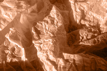 Crumpled kraft paper lies on the surface. Color peach fuzz