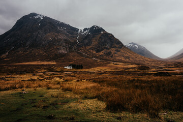 Beautiful vista with the white house and waterfalls near Three Sisters Mountains in Glencoe, the...