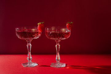 Two glasses of rose sparkling wine on red background romantic valentine's day concept