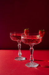 Two glasses of rose sparkling wine on red background romantic valentine's day concept