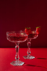 Two glasses of rose sparkling wine on red background romantic valentine's day concept