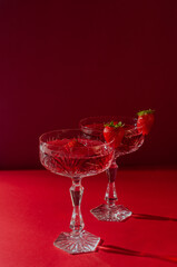 Two glasses of rose sparkling wine on red background romantic valentine's day concept