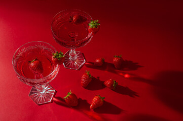 Two glasses of rose sparkling wine on red background romantic valentine's day concept