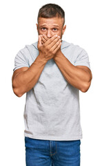 Handsome muscle man wearing casual grey tshirt shocked covering mouth with hands for mistake. secret concept.