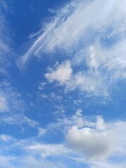 Blue sky with some like paint brush painted clouds