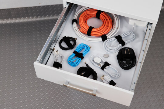 Drawer with cables tidy in a garage cabinet.