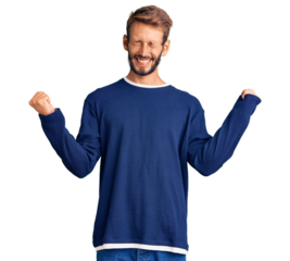 Handsome blond man with beard wearing casual sweater very happy and excited doing winner gesture with arms raised, smiling and screaming for success. celebration concept.