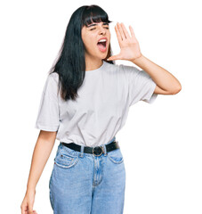 Young hispanic girl wearing casual clothes shouting and screaming loud to side with hand on mouth. communication concept.