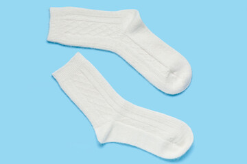 White knitted socks on blue background