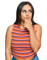 Young brunette woman wearing casual clothes with hand on chin thinking about question, pensive expression. smiling with thoughtful face. doubt concept.
