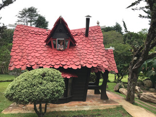 Happy Caucasian red-haired girl in miniature house with red roof in European style