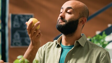 Shop owner gives lemons to client to smell and enjoy aromatic fresh citrus scent, man buying...