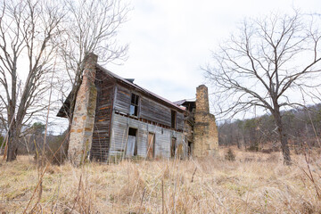 Fototapeta na wymiar Rundown rural abandoned house with dead grass and trees in West Virginia