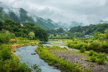 Naklejka na ściany i meble River runs through mountain village