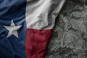 waving flag of texas state on the old khaki texture background. military concept. - obrazy, fototapety, plakaty