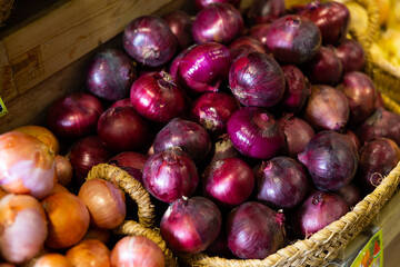 Obraz premium Closeup of fresh purple ripe onion on market counter, onion background