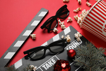 Bucket of popcorn with movie clapper, 3D glasses and Christmas decor on red background