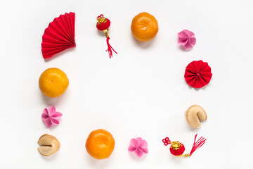 Frame made of fortune cookies with mandarins and Chinese symbols on white background. New Year celebration