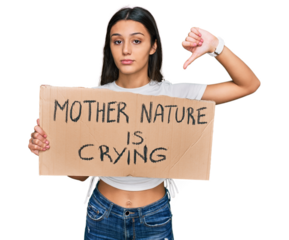 Young hispanic girl holding mother nature is crying protest cardboard banner with angry face, negative sign showing dislike with thumbs down, rejection concept