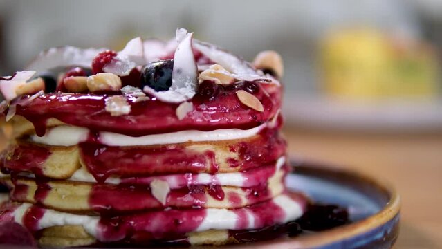 4K Closeup view of Stack of pancakes with chocolate, honey, strawberry, blue berry on top in plate, delicious dessert for breakfast. High quality 4k footage