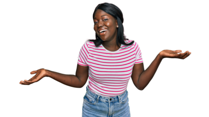 African young woman wearing casual striped t shirt clueless and confused expression with arms and hands raised. doubt concept.