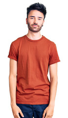 Fototapeta premium Young hispanic man wearing casual clothes with serious expression on face. simple and natural looking at the camera.