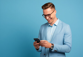 Young adult smiling happy pretty man holding mobile phone, typing message, doing ecommerce shopping on cell, isolated on blue background