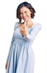 Fototapeta premium Young beautiful girl wearing casual clothes beckoning come here gesture with hand inviting welcoming happy and smiling