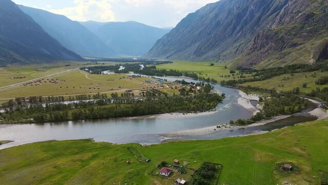 Aerial view of the beautiful valley and river surrounded by high mountain ranges