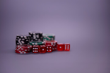 Casino games and gambling concept with stacked poker chips and red dice used in the game of craps. Copy space.