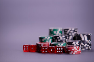 Casino games and gambling concept with stacked poker chips and red dice used in the game of craps. Copy space.