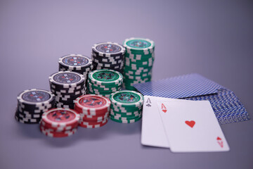 Poker cards and stacks of poker chips on a grey background. Poker game concept.