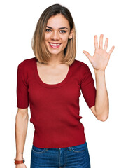 Young blonde girl wearing casual clothes showing and pointing up with fingers number five while smiling confident and happy.