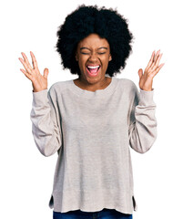 Young african american woman wearing casual clothes celebrating mad and crazy for success with arms...