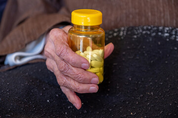 old woman hands holding medicine pills