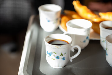 Cup of coffee with sun beams and sweets