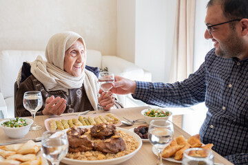 Family eating together with multi generation members in modern living room