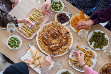 Top view for Arabian family having dinner together on wooden table with father,mother,grandfather,grandmother and son
