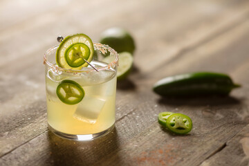 Spicy Margarita with fresh jalapeno and lime on wood background