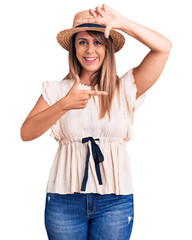 Young beautiful woman wearing summer hat and t-shirt smiling making frame with hands and fingers with happy face. creativity and photography concept.