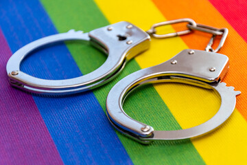 Handcuffs on the LGBT flag. Concept: criminal prosecution in Russia, gender restriction of freedom.