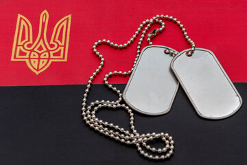 Army medallion of a soldier on the background of Ukrainian red and black flag. Concept: fight for freedom, war in ukraine, mobilization and conscription.