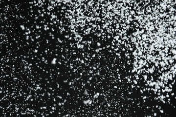 White snow falling down on black background