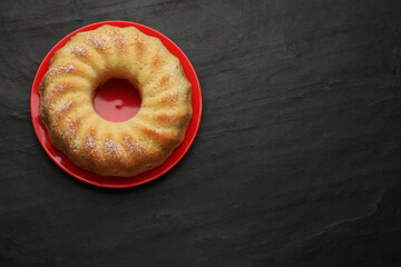 Delicious freshly baked sponge cake on black table, top view. Space for text
