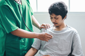 Doctor using stethoscope to listening heart beat of male patient in the clinic