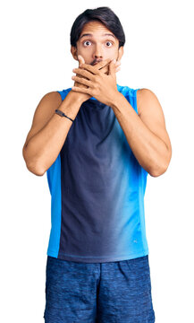 Handsome hispanic man wearing sportswear shocked covering mouth with hands for mistake. secret concept.